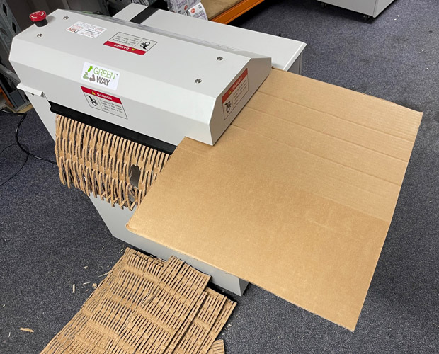 Cardboard being perforated to make packaging.